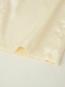Détail de tissu satiné champagne avec texture lisse et couture d'ourlet de haute qualité