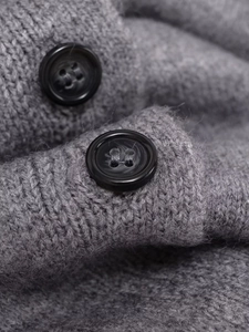 Close-up of grey knit cardigan featuring thick fuzzy texture and marbled black button detail