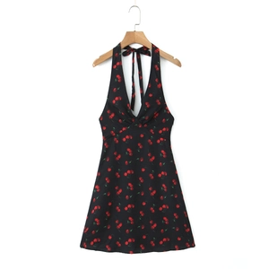 Detail of a black cherry print halter mini dress featuring a V-neckline with knot detail