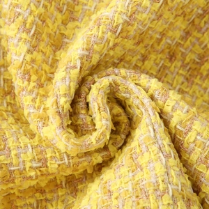 Detailed texture of yellow tweed fabric for women's short Chanel style jacket