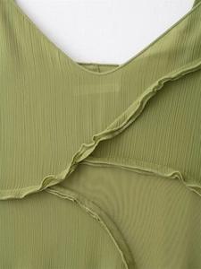 Detail of green V-neck dress featuring pleated texture and mesh ruffles detailing