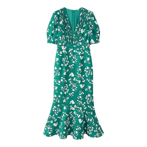 Détail d'une robe fleurie verte avec col en V, manches bouffantes et ourlet plissé