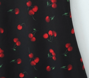 Close-up of sweet cherry print on black fabric showing smooth texture and pattern detail
