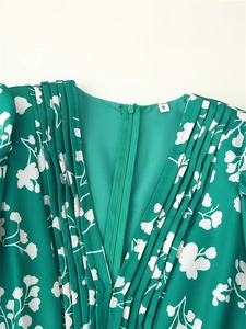 Détail de robe verte fleurie montrant le décolleté en V plissé et la fermeture invisible