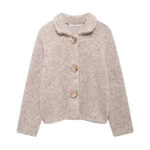 Détails de boutons floraux sur un gilet en mohair doux de couleur beige avoine