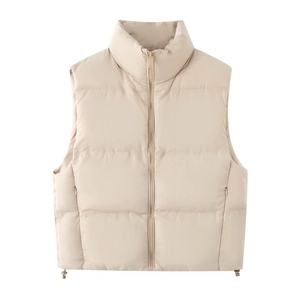Detail of beige puffer vest featuring standing collar, zip-up front, and adjustable drawstring hem