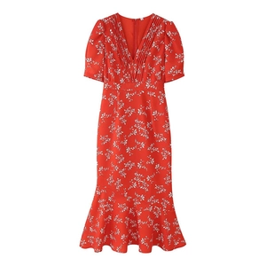 Détail de la robe fleurie rouge avec col en V plissé et manches bouffantes sur fond blanc