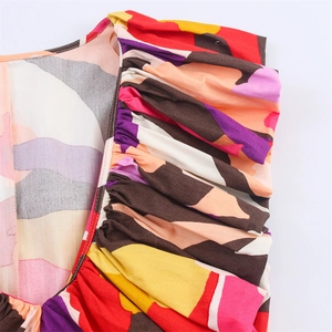 Close-up of abstract colorful print fabric with pleated detail on sleeveless dress