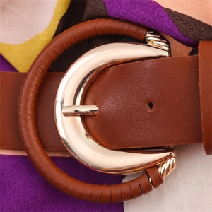 Close-up of a brown leather belt featuring a circular buckle with gold-tone metal hardware