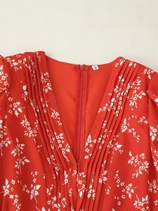 Détail du col en V plongeant plissé sur cette robe rouge à imprimé floral chic