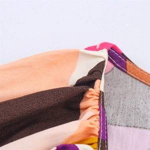 Close-up of colorful striped fabric showing detailed smocking and stitching process