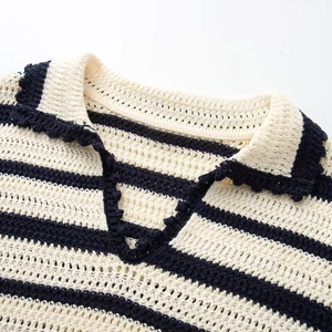 Détail du col polo festonné sur une robe en maille rayée avec des motifs au crochet
