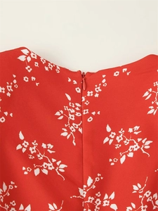 Détail d'une robe rouge à fleurs avec fermeture éclair invisible et texture de tissu fine