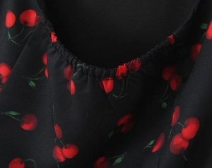 Detail of the black cherry print dress showing the elastic ruffled neckline and fabric