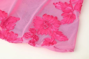 Detailansicht aus rosa Netzstoff mit 3D-Bandblumenstickerei und exquisiter Verarbeitung