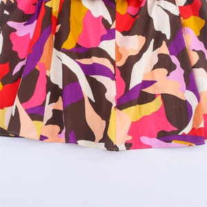 Detailed macro view of multi-color abstract print and stitching on the dress hemline