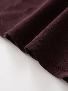 Macro shot of dark red knit fabric texture showing premium dense stitching details