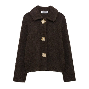 Gros plan d'un cardigan marron en maille bouclée avec des boutons dorés en forme de fleur