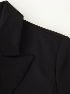 Détails du revers classique d'un blazer noir et coutures d'épaule fines sur tissu de qualité