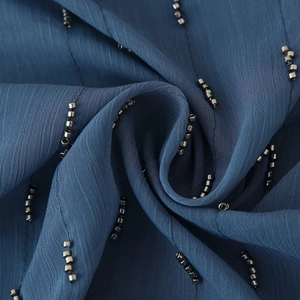 Blue strapless top with elegant beaded lines and pleated texture in macro detail