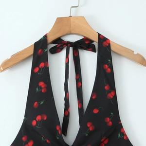 Slim fit black halter mini dress with red cherry print and open back for a retro look