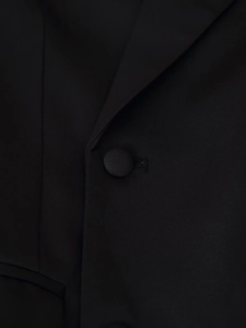 Vue macro d'un bouton recouvert de tissu et texture fine sur ce blazer noir cintré
