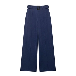 Detail of high-waisted navy wide-leg trousers featuring a twill texture and gold buckle belt