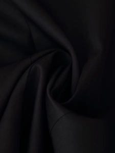 Gros plan sur la texture du tissu sergé noir montrant le tissage pour blazers