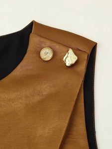 Detailed macro view of bronze satin fabric with pearlescent and hammered gold buttons