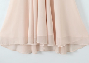 Close-up of layered irregular hemline on a flowing light pink chiffon halter dress