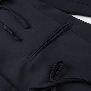Detailed view of the neat stitching and elegant bow tie design on a blazer jacket