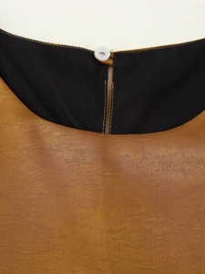 Detail of contrast neckline and water-drop back opening with single button on glossy vest