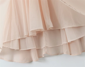 Detailed view of layered chiffon hemline with fine stitching on a pink halter dress