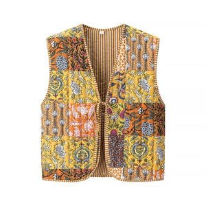 Détail d'un gilet matelassé bohème avec motifs patchwork floraux et fermeture à nouer