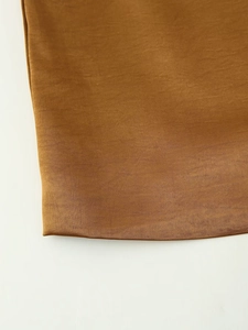 Close-up of the smooth amber satin fabric texture and premium stitching details on the vest