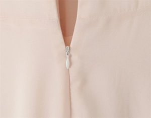Close-up of invisible zipper and delicate sewing detail on pink chiffon dress
