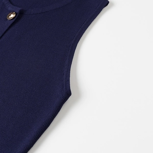 Detail of navy rib-knit sleeveless top featuring a decorative gold round button accent