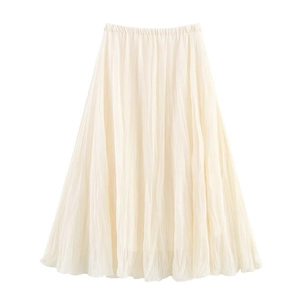Detail shot of the cream-colored pleated skirt showing fine mesh fabric and micro-textures