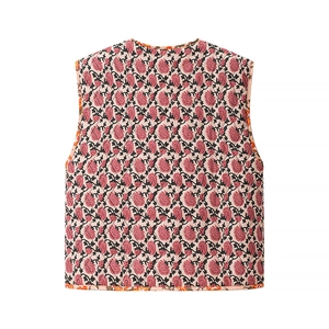 Détail du gilet matelassé rose avec motif floral vintage et bordure orange contrastée