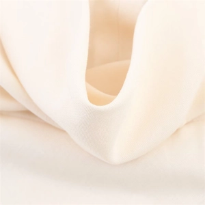 Close-up of off-white chiffon fabric showing lightweight texture and pleated drape