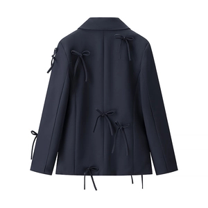 Detail showing back decorative bow buckles on navy long sleeve blazer jacket