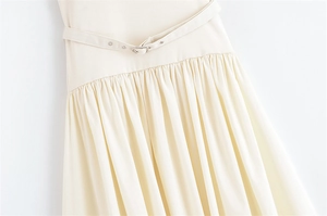 Close-up of the pleated waist design and adjustable buckled belt on an elegant dress