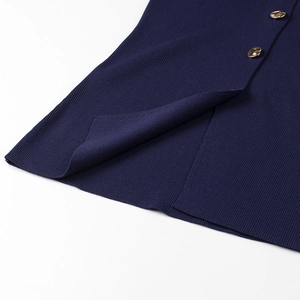 Close-up of dark blue ribbed knit fabric with side slit and gold button accents