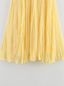 Detailed view of the light yellow pleated mesh fabric texture on a women's midi skirt