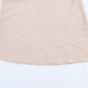 Detail shot of apricot summer dress showing high-quality cotton fabric and flat seam stitching