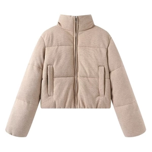 Close-up of knit texture and metal zipper on women's light beige puffer jacket