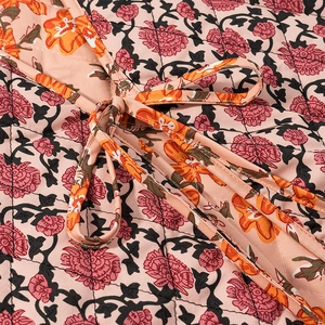 Gros plan sur un gilet matelassé à fleurs avec détail de laçage et motif floral vintage