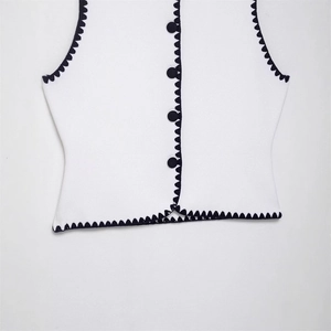 Women's white knitted vest with black wave trim and decorative buttons, vintage style