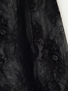 Gros plan sur le tissu en dentelle noire avec motifs floraux vintage et maille fine