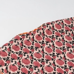 Gros plan d'une veste à fleurs matelassée avec doublure et surpiqûres contrastées